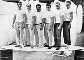 Workers stand on a Foss Foam surfboard blank.