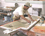 Worker applies fiberglass to a rudder mold.